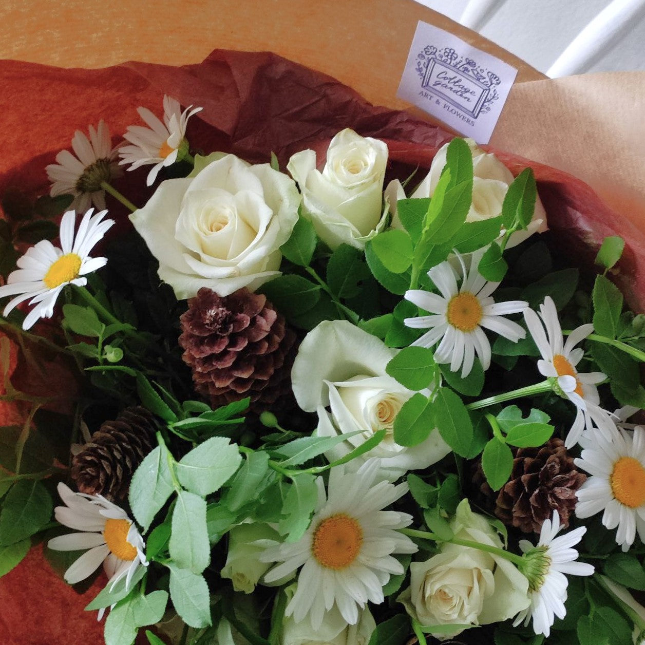 Summer forest bouquet with daisies, white mini roses and cones