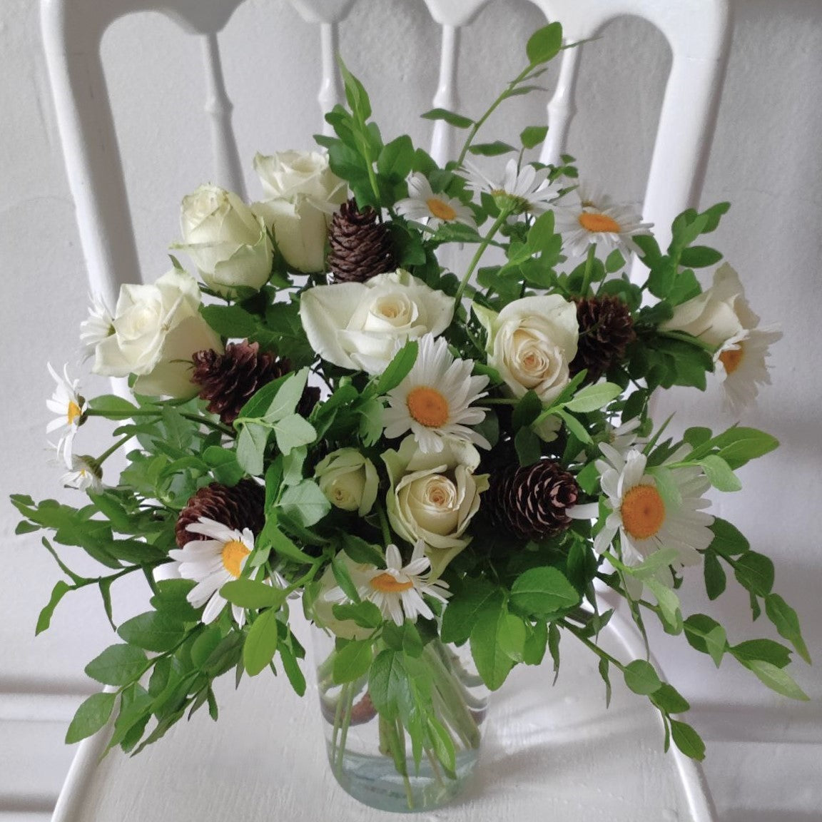 Summer forest bouquet with daisies, white mini roses and cones