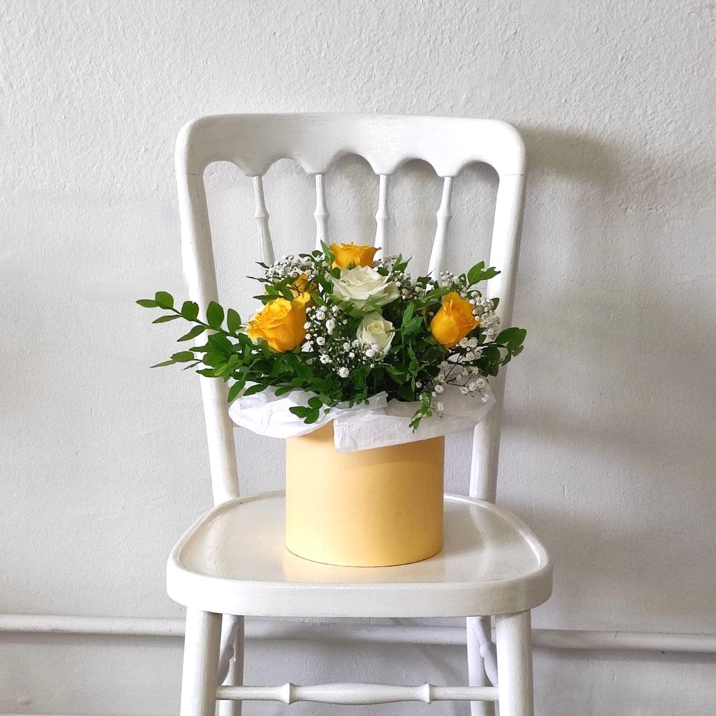 Composition with yellow roses in a box