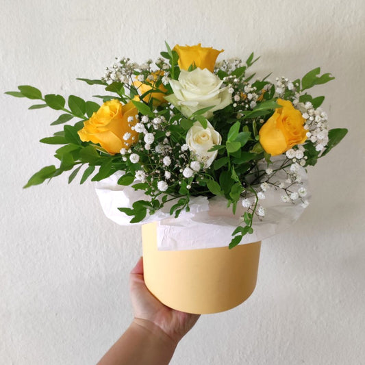 Composition with yellow roses in a box