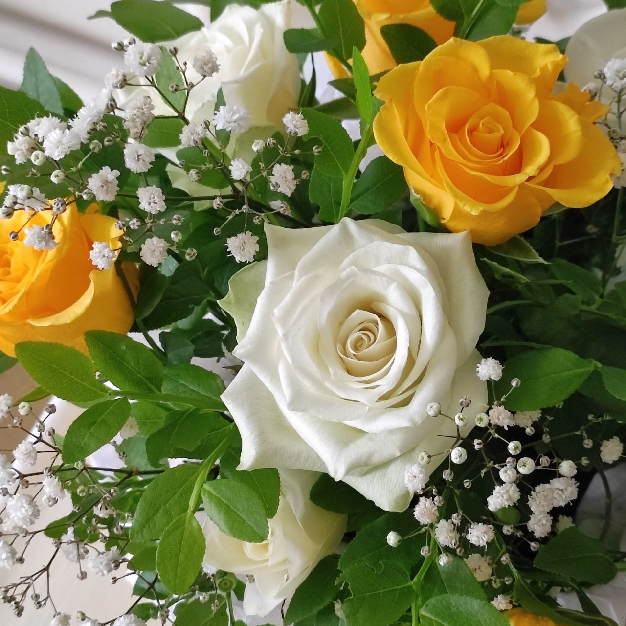 Composition with yellow roses in a box